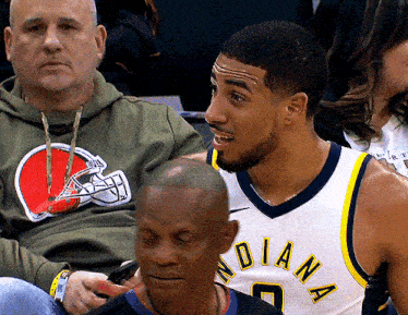 a man wearing an indiana jersey sits in a crowd