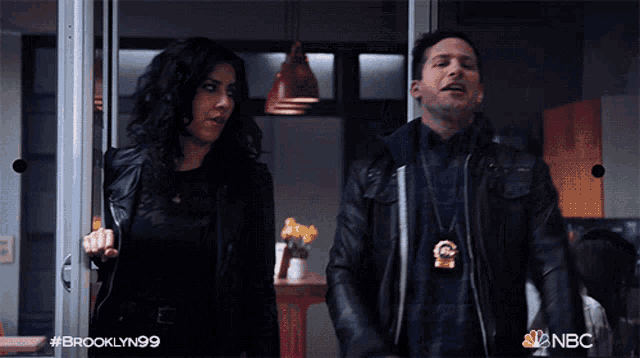 a man and a woman are standing in a doorway with brooklyn99 written on the bottom of the screen
