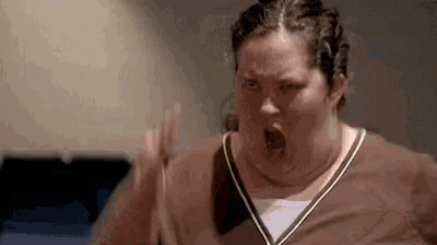 a very fat woman is making a funny face with her mouth open and her hands up .