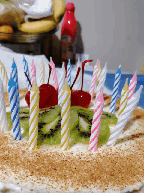 a birthday cake with candles and kiwi on it