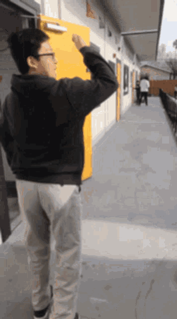 a man stands in front of a yellow door