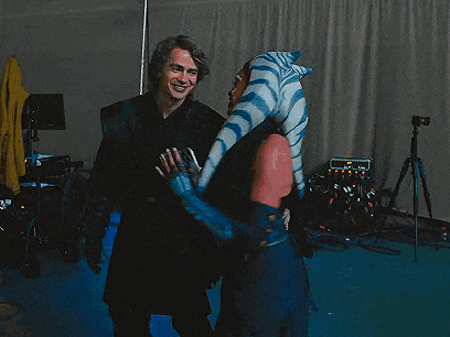 a man and a woman are standing next to each other in a dark room .