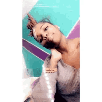a woman with dreadlocks is taking a picture of herself .