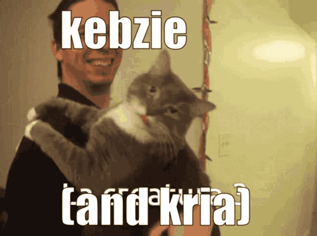 a picture of a man holding a cat with the caption kebzie tandkrial