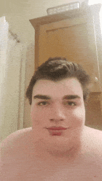 a man without a shirt is looking at the camera