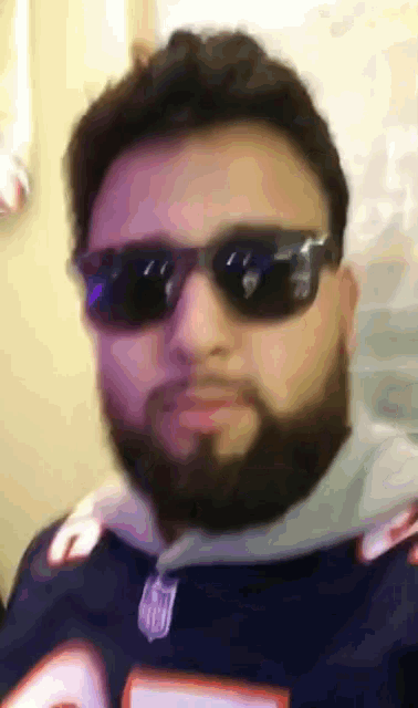 a man with a beard wearing sunglasses and a jersey with the number 5 on it