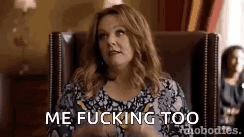 a woman is sitting in a chair with her hands in her pockets and says `` me fucking too '' .