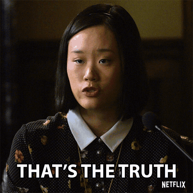 a woman speaking into a microphone with the words that 's the truth behind her