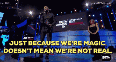 a man stands on a stage with a microphone and says just because we are magic