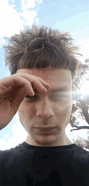 a close up of a person 's face with a hand on their forehead