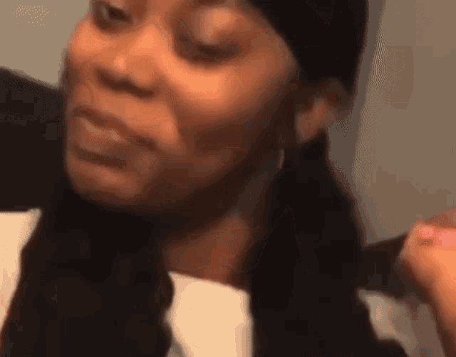 a close up of a woman 's face making a funny face while wearing a hat .