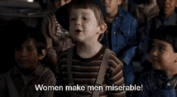 a group of children are sitting in a room and a boy is talking about women making men miserable .
