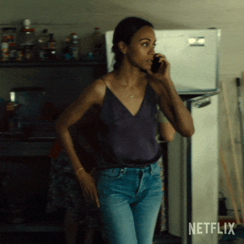 a woman is talking on a cell phone in front of a netflix logo