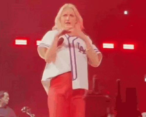 a woman is singing into a microphone on a stage .
