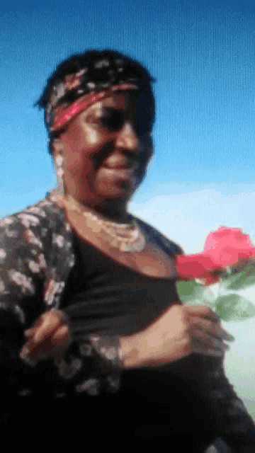 a woman holding a red rose in her hand