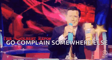 a man is holding a microphone and saying `` go complain somewhere else '' while standing in front of a podium .