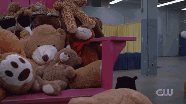a woman in a superman costume is standing in front of stuffed animals