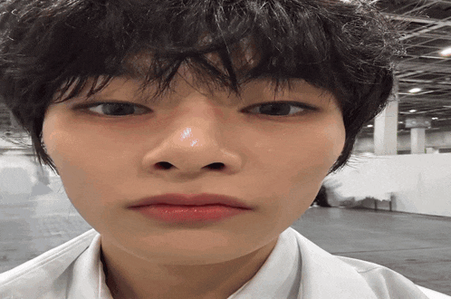 a close up of a person 's face with a white shirt