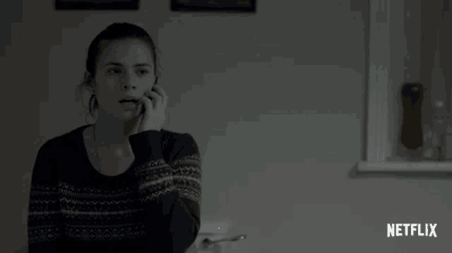 a woman talking on a cell phone with a netflix logo on the bottom right