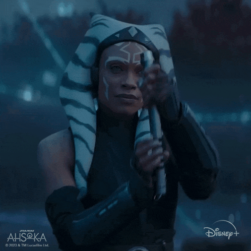 a woman in a star wars costume is holding a light saber in front of a disney logo