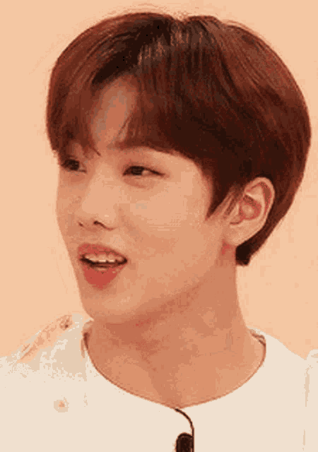 a close up of a young man 's face with a white shirt on .