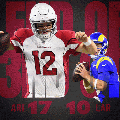 a cardinals player is holding a football in front of another player