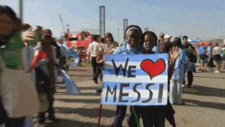 a couple of people holding a sign that says we love messi