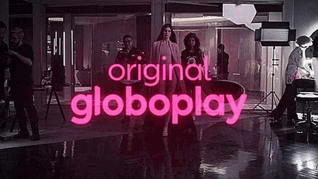 a woman stands in front of a sign that says globoplay