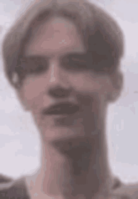 a close up of a person 's face with a blurry background .