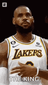 lebron james is a basketball player for the lakers and is wearing a white and yellow jersey .
