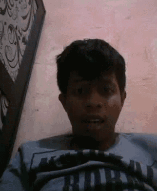 a man is making a funny face while wearing a blue shirt .