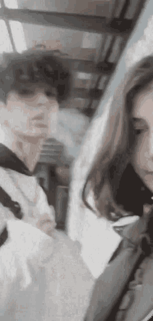 a man and a woman are standing next to each other on a train .
