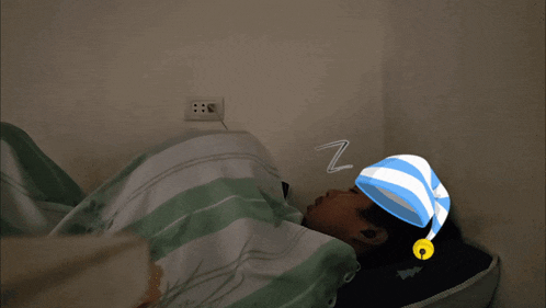 a person wearing a blue and white striped sleep cap is sleeping