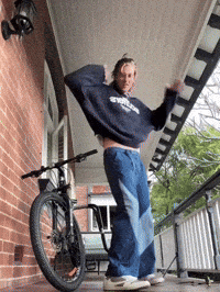 a person standing on a porch with a bicycle