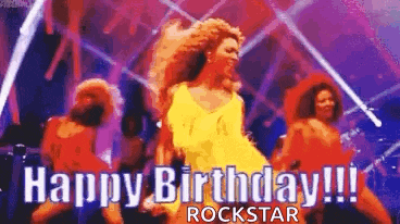 a woman is dancing on a stage with the words `` happy birthday rockstar '' .