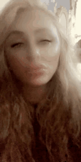 a close up of a woman making a face with her eyes closed