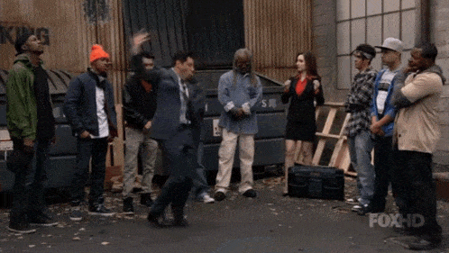 a group of people are standing in front of a dumpster with the word king on it