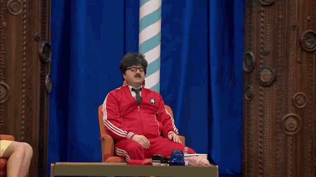 a group of people are sitting in a theater laughing and clapping their hands .