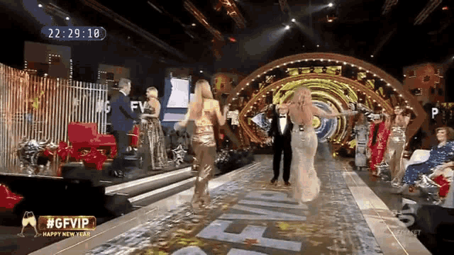 a group of people are dancing on a stage with a sign that says #gfvip on it