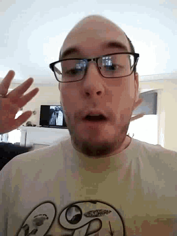a man wearing glasses and a t-shirt with a smiley face on it