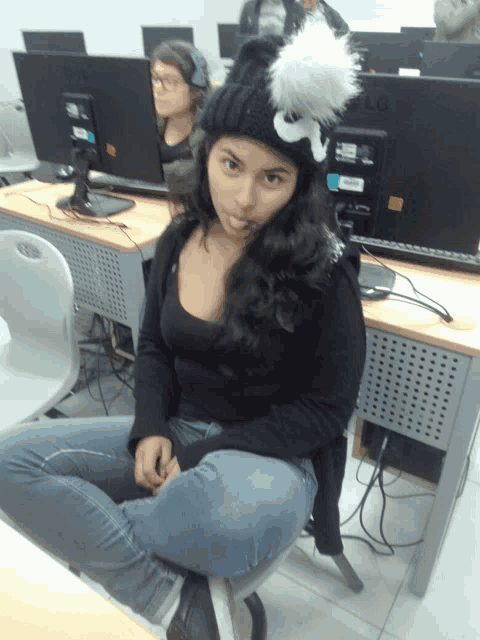 a woman sits in front of an lg monitor