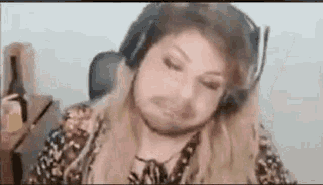 a woman is wearing headphones and making a funny face while sitting in a chair .