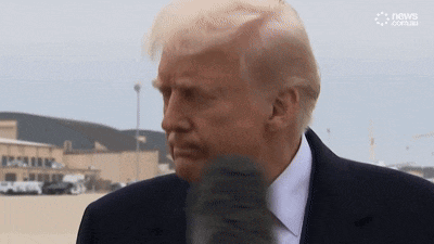 donald trump is talking into a microphone while wearing a black suit and white shirt