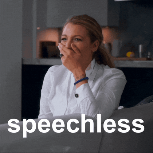 a woman sits on a couch covering her mouth with her hand and the word speechless is on the bottom right