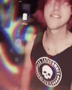 a woman wearing a black tank top with a skull on it that says " all hail the king "