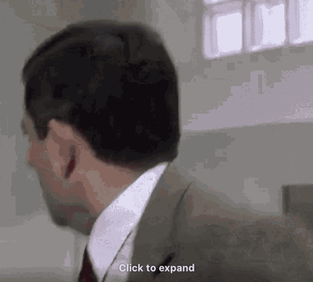 a man in a suit and tie is talking to another man .