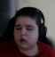 a young boy wearing headphones and a red shirt is sitting in a chair .