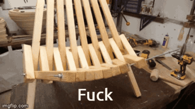 a wooden chair is sitting on a table with the words fuck written on it