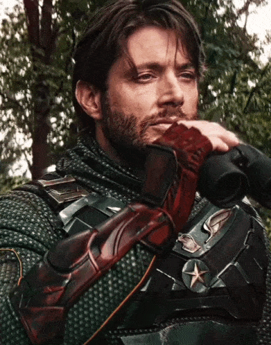 a man with a beard is holding binoculars in his right hand