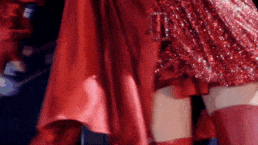 a woman in a red dress and red thigh high socks is standing next to another woman .